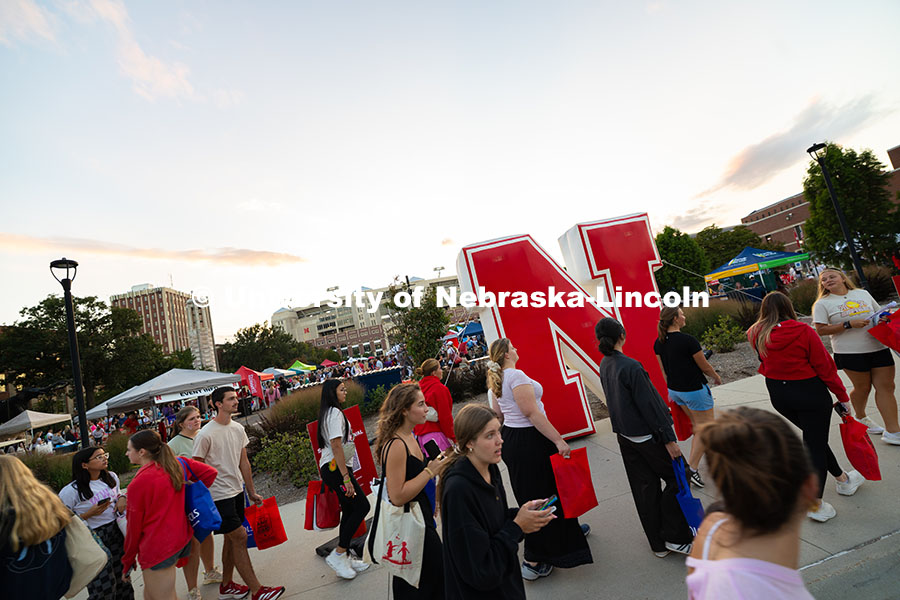 Students walk by an inflatable "N" during the Big Red Welcome Street Festival on the Memorial Stadiu