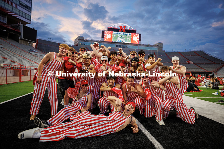 The Husker Bib Crew wear red and white striped bib overalls and pose for a photo during the Nebraska