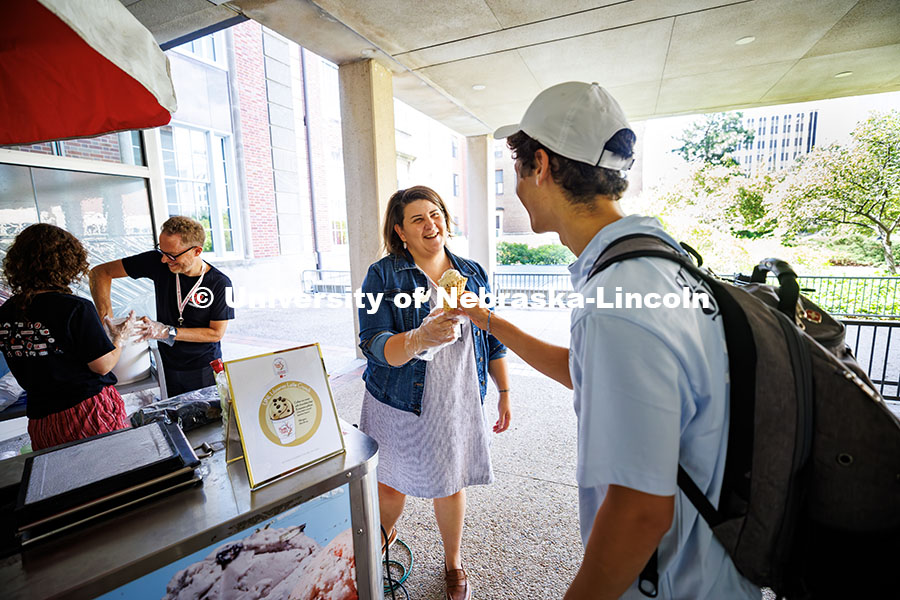 Elizabeth Lorang, the Dean of University Libraries, hands an ice cream cone to Yakub Islamov, a seni