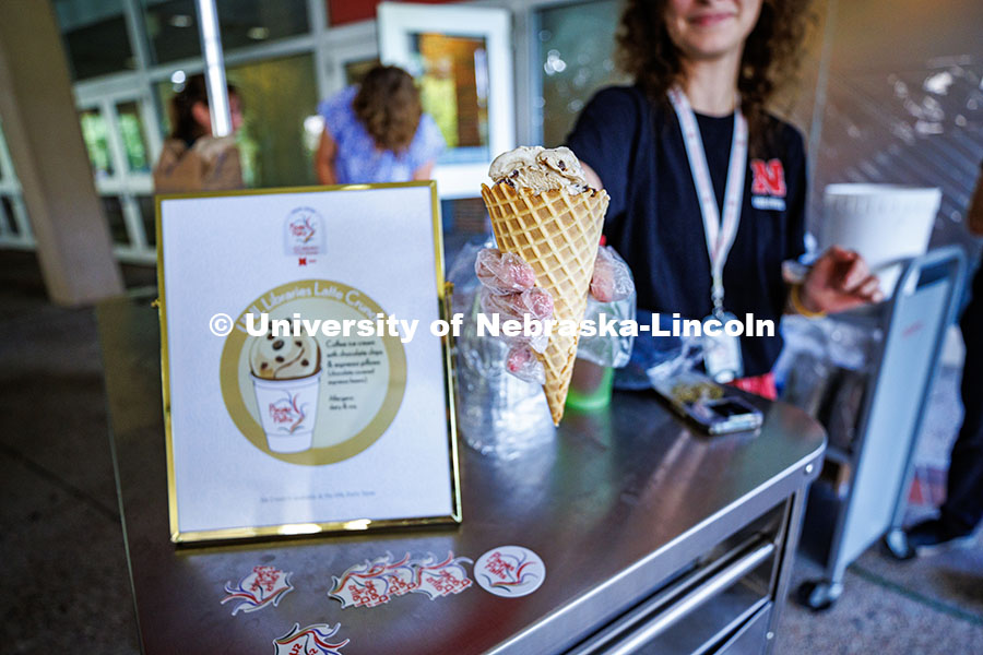 A University Library staff member hands an ice cream cone to a student in celebration of the Pages t