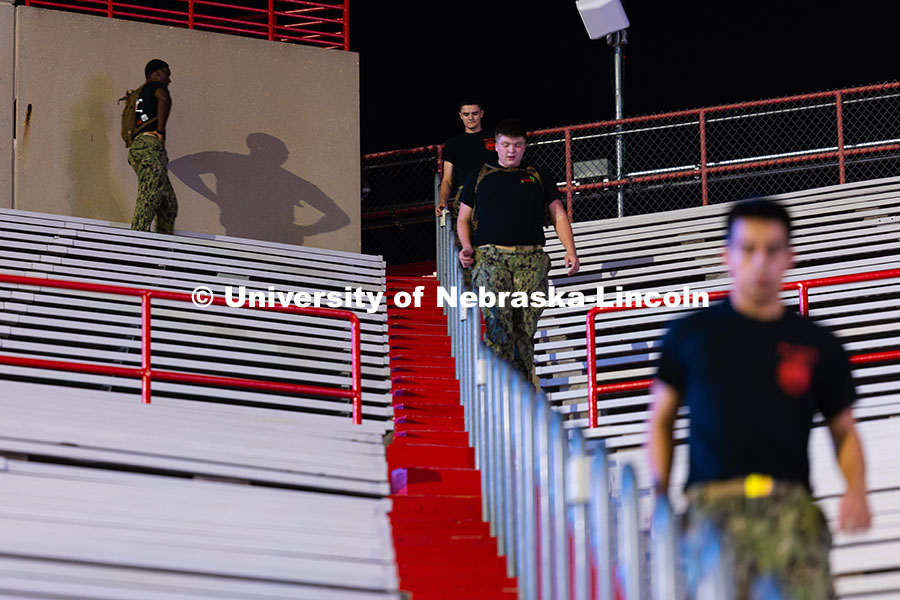 An NROTC midshipman's shadow shows him catching his breath between running up and down staircases fo