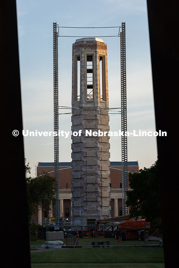 Morning sunlight touches Mueller Tower's exposed brick as scaffolding supports surround it as constr