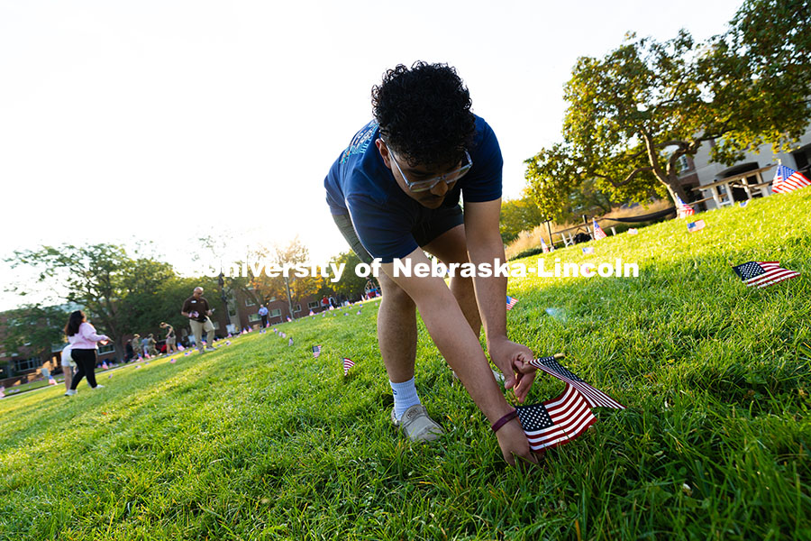 Leonardo Luna-Duran, a sophomore in the Clifton Builders management program, places flags in the gra