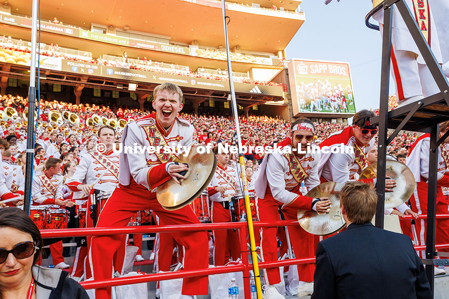 Davin Seeger, cymbalist for the Cornhusker Marching Band, crashes his cymbals and cheers during the 
