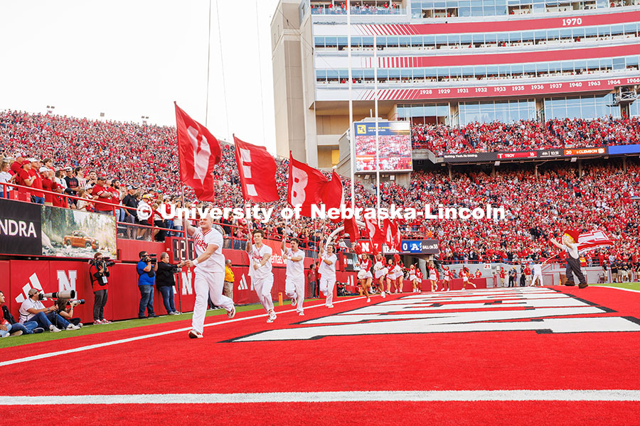 The Nebraska Spirit Squad runs along the end zone with flags that spell out Nebraska after a touchdo