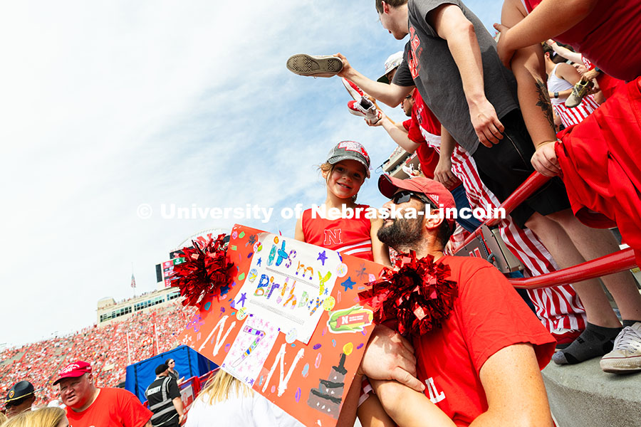 250913_NU_vs_HCU_7484.jpg Chris Pelster lifts his daughter, Eden, as they wait for the Scarlets the take to the field. Eden tu