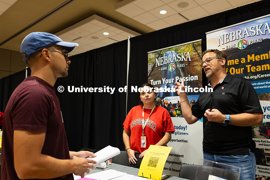 Dan Schmidt, a UNL alumni and parent of two UNL students, and Jen Jenkins chat with Matt Girard, a s