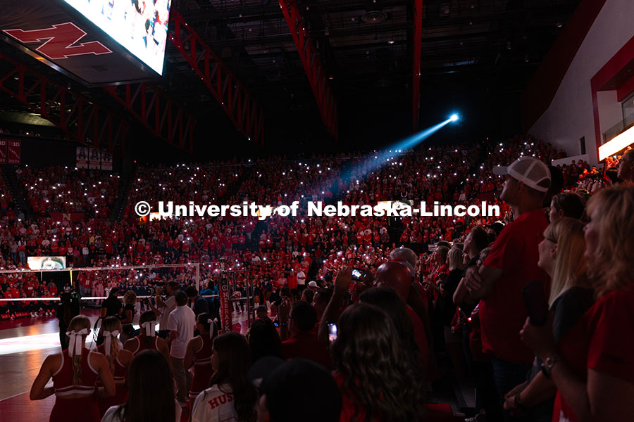 A spotlight shines onto the volleyball court during a pregame video before the game against the Univ