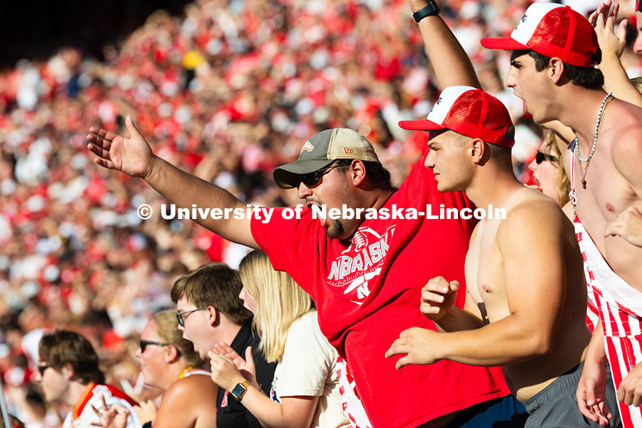250920_NU_vs_Michigan_8185.jpg Blake Byerly, a junior studying ag economics, raises his arms to gesture "stand up" to students arou