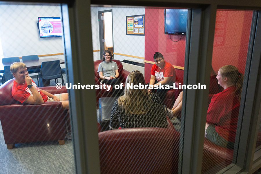 Students chat outside of the Honors Program staff offices with Sawyer Smith (in black dress), coordi