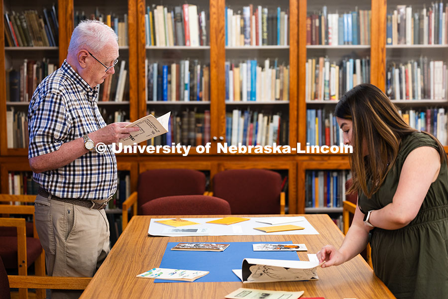 Steve Shively (left) and Daniela Martinez look through vintage student-produced publications. The li