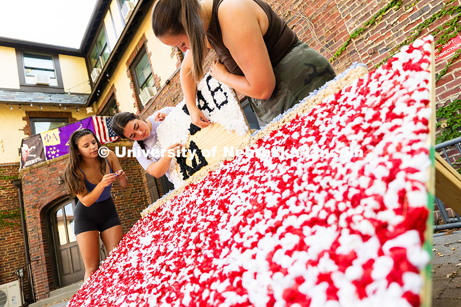 Kappa Delta members Maddie Balus, Jordan Tipton and Ella Reifenrath glue pom-poms made from party na