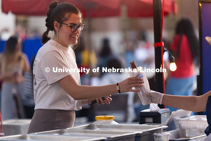 Lucy Salyer, a junior, gets a churro from Papi Churros during the first Homecoming Yard Show, hosted