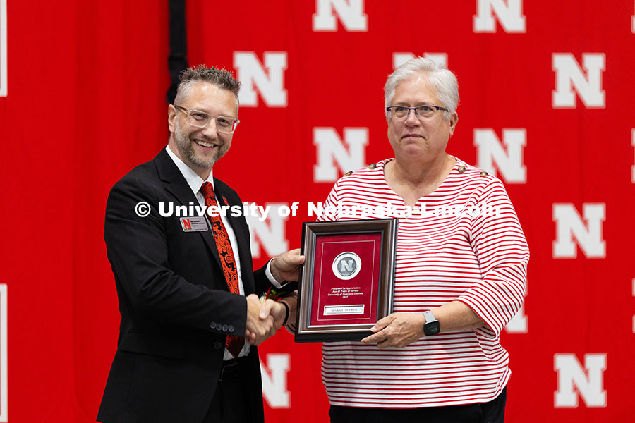 Susan Budler poses for a photo with Ben Lennander after receiving a plaque recognizing her 45 years 