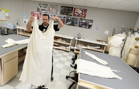 Michael Burton works with clothing he produced for the story of Anna, a slave who jumped from a wind