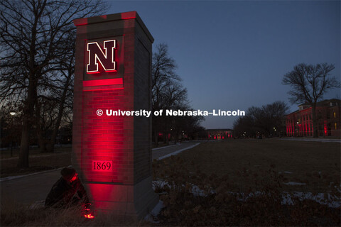 Seth Carne of TMS installs lights on the East Campus gateway / entrance columns for Glow Big Red. Gl