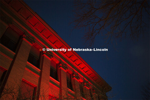 Agriculture Hall lit up red during Glow Big Red. Glow Big Red bathes the campuses with red lights as