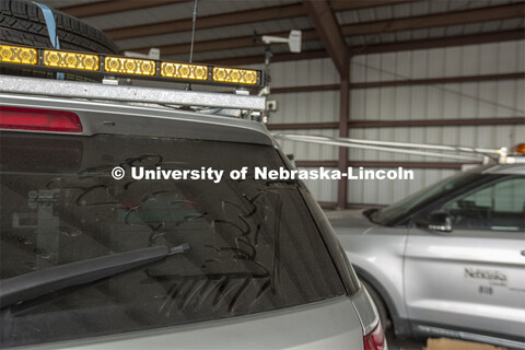 A thunderhead rolls across the dust on the back window of a Nebraska storm chase vehicle. The TORUS 