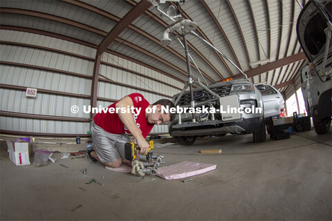 Graduate student Alex Erwin drills a pipe that will hold an instrument cluster on Nebraska's newest 