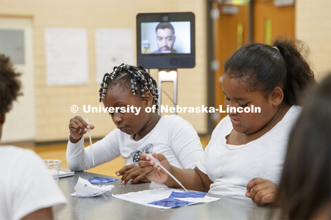 Students test nano treated fabric for water absorption as Soham Patel, a UNL computer science major,