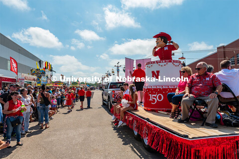 Herbie in cake parade float, flexing for kids in crows. The University of Nebraska represents and ce