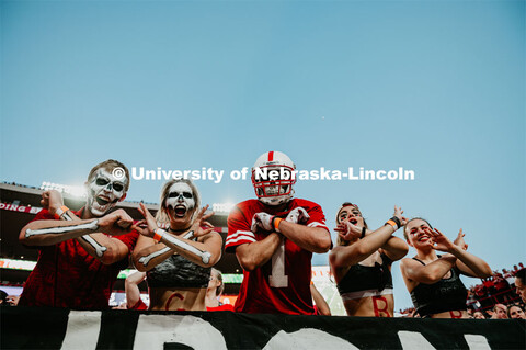 Student section painted up like skeletons, throwing the bones. Nebraska vs. Northern Illinois footba