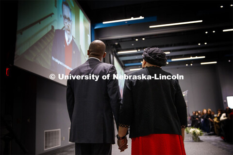 Marco Barker and Anna Shavers watch a video by UNL Chancellor Ronnie Green congratulating Shavers on