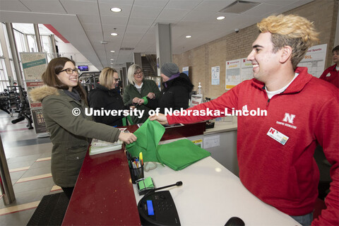 Kaitlyn Waller receives a bandana from Nick, an East Campus Rec employee.  Megan Schaefer watches Me