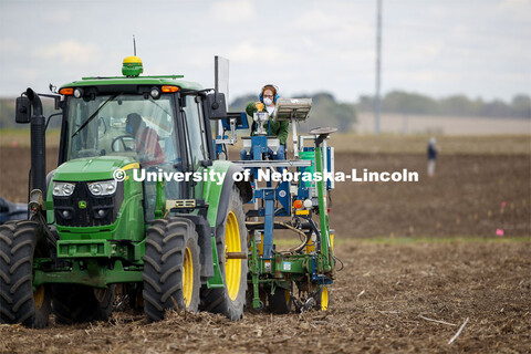 Christine Smith pours a packet of seeds into the hopper as the tractor slowly travels the field. Jam