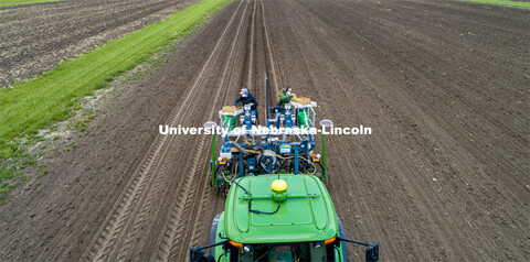 Brandi Sigmon and Christine Smith pours a packet of seeds into the hopper as the tractor slowly trav