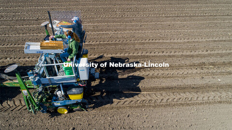 Brandi Sigmon and Christine Smith pours a packet of seeds into the hopper as the tractor slowly trav