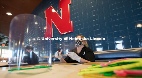 Dinning Services employees, Rochan Pinho, Janet Nichols and Dami Olsen, assemble face shields at Har