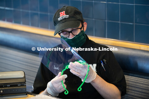 Dinning Services employees, Rochan Pinho, Janet Nichols and Dami Olsen, assemble face shields at Har