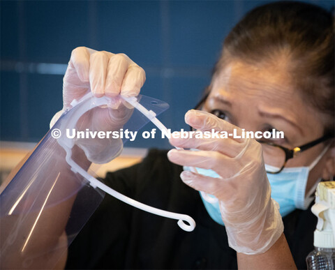 Dinning Services employees, Rochan Pinho, Janet Nichols and Dami Olsen, assemble face shields at Har