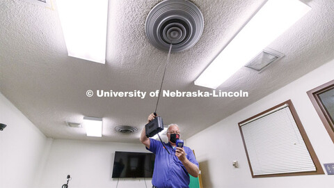 Dave Tyler, Control Systems Tech, uses a hot wire anemometer to measure air coming from a vent in a 