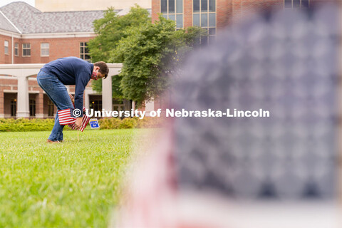 Junior political science major Cameron Collier places American flags across the Donald and Lorena Me