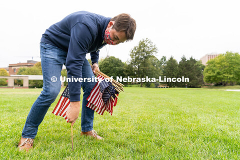 Junior political science major Cameron Collier places American flags across the Donald and Lorena Me