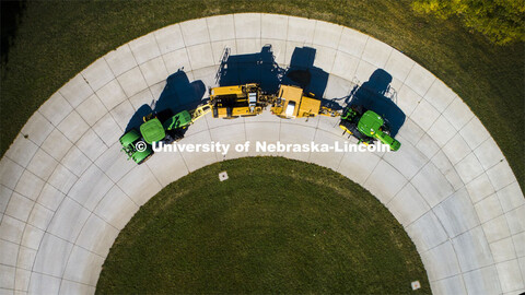 A tractor pulls the test car (yellow) and an additional tractor for weight as it rounds the test tra