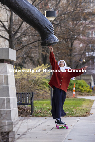 Khadieja Abuzaho, freshman from Lincoln, touches the foot of Archie the Mammoth in front of the Nebr