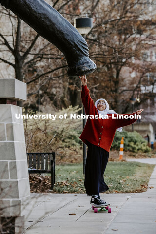Khadieja Abuzaho, freshman from Lincoln, touches the foot of Archie the Mammoth in front of the Nebr