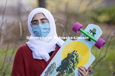 Khadieja Abuzaho, freshman from Lincoln, touches the foot of Archie the Mammoth in front of the Nebr