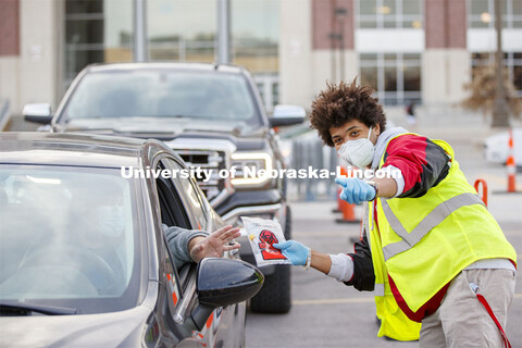 Alex Chapman, senior in music and a student worker at the testing site, directs a drive-up patient t