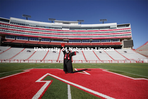 Macy Behrens, senior in advertising and public relations and also graphic design, poses in regalia t