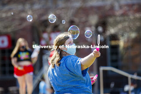 Lanie Stutz, CARE Advocate for Student Affairs, blows bubbles outside the Nebraska Union.  Students 