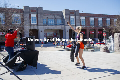 A young woman takes a selfie outside the Nebraska Union. Students have fun at the Spring Breakout, a