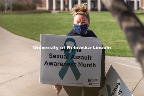 CARE Advocate Melissa Wilkerson organizes signs before placing them at the Nebraska Union Greenspace