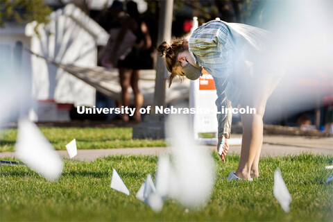 Sophomore psychology major Violet Hudson places flags across the Nebraska Union Greenspace. Flags an