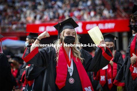 Lauren Leapley gestures to a friend as she processes to receive her College of Business diploma. UNL