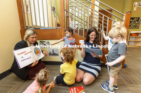 Holly Hatton-Bowers, left, and Carrie Clark read to the children at the UNL Children’s Center. Jul