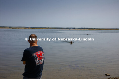 Students dive in Lake Ogallala under the watchful eye of Bill Belcher, assistant professor of anthro